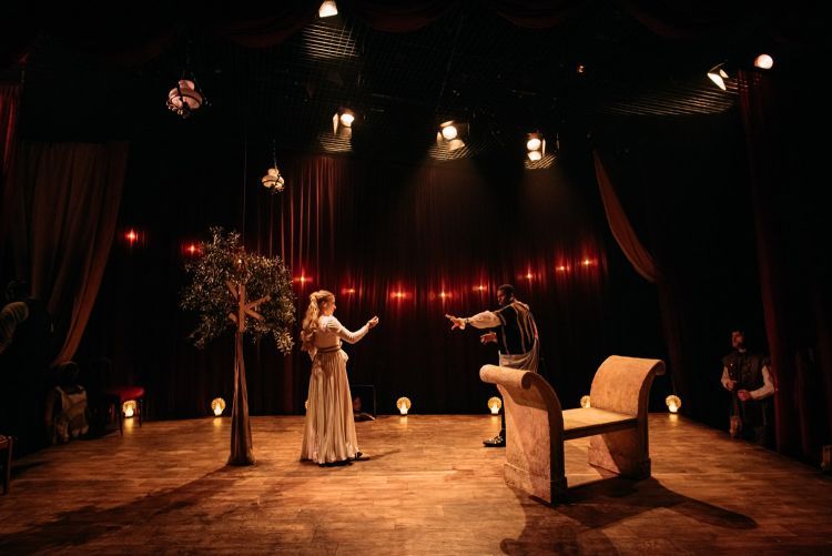 Two actors in period costumes on the set of Red Velvet